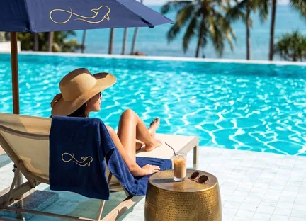 A guest relaxing by a turquoise pool